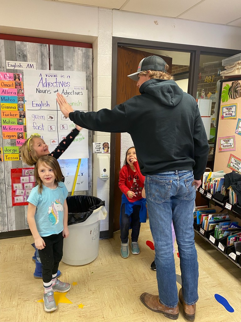Preston Daufeldt giving high fives to Kindergarten students